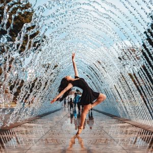 Ballet dancer, dancing in the middle of an arched water fountain.